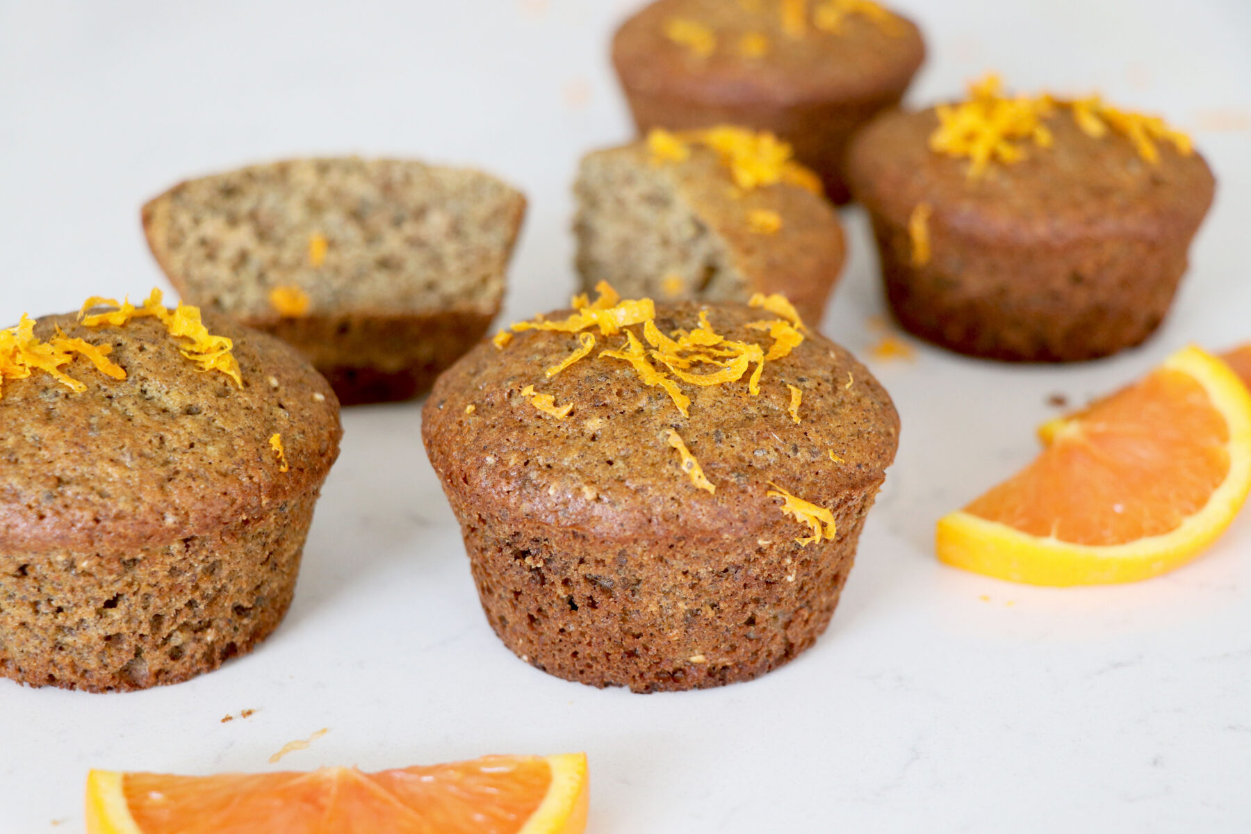 Muffins with orange zest and slices on the side.