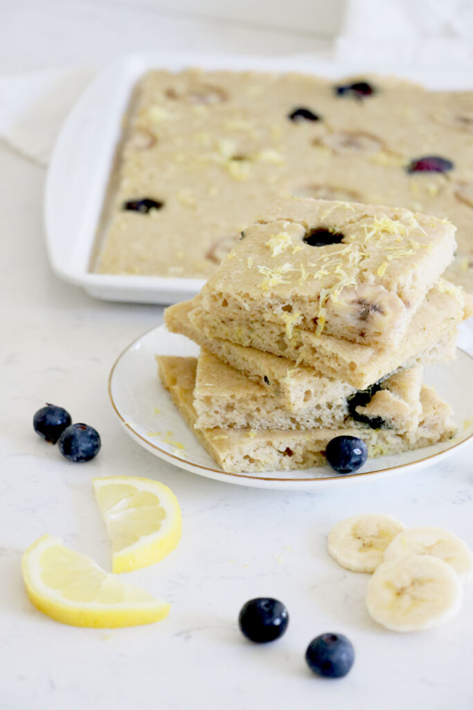 Sheet pan with pancakes and white plate with pancakes cut into squares.