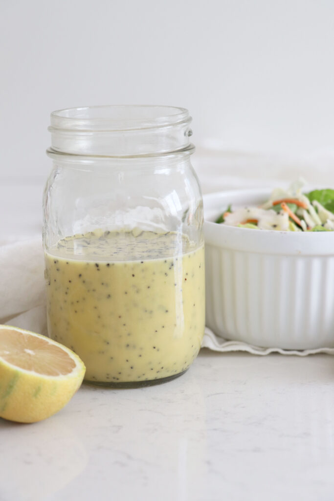 Glass jar of lemon poppy seed dressing.