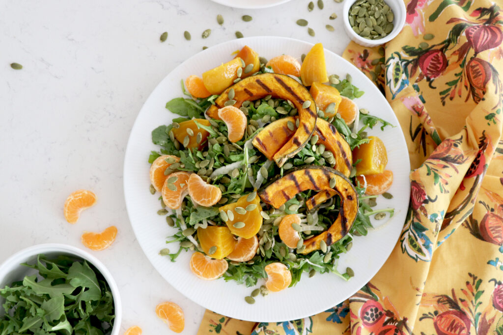 Platter of salad topped with pumpkin seeds