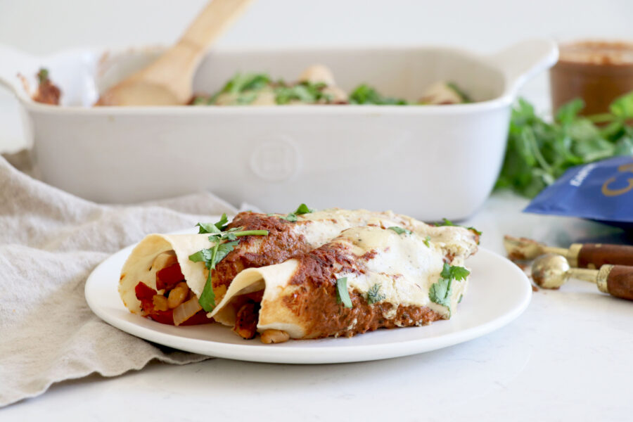 Plate with 3 enchiladas and baking dish in background.