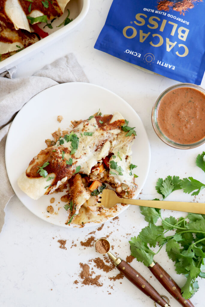 White plate with enchiladas surrounded by Cacao Bliss bag and toppings.