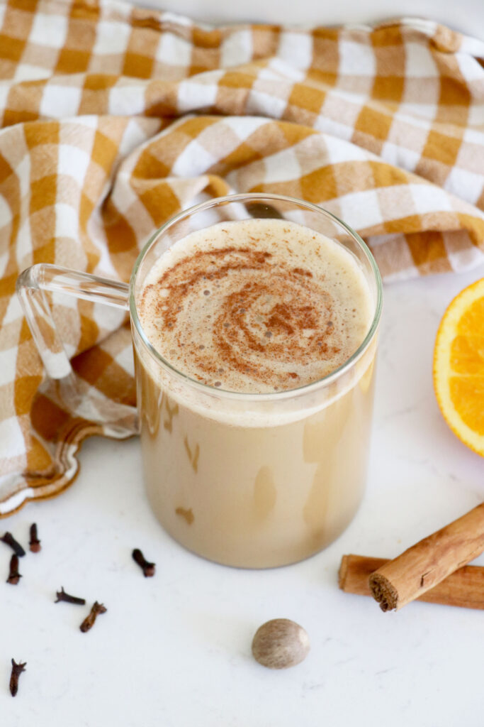 Glass coffee mug with pumpkin spice latte and cinnamon swirl on top. 