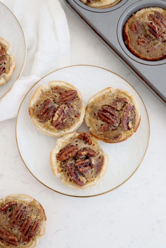 White plate with 3 mini pies and pie pan on top right.