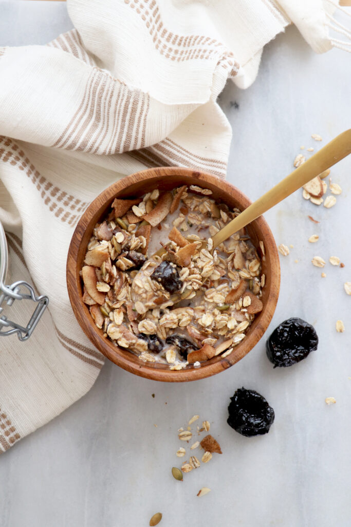 Vertical photo with bowl of muesli with gold spoon inside.