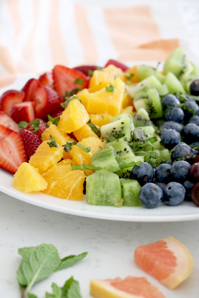 Fruit salad layered on white plate.