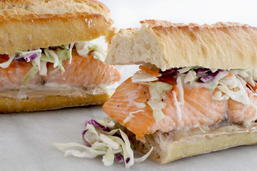 two salmon sandwiches in entire photo topped with a coconut citrus slaw
