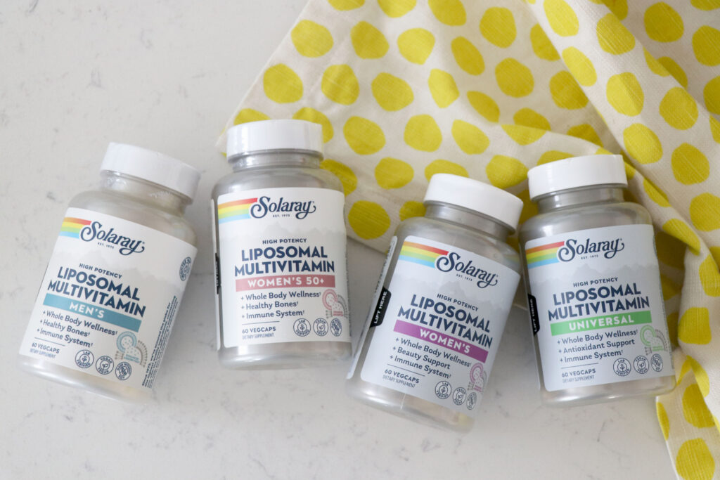 4 types of multivitamins on a counter with lemon towel on the right side.