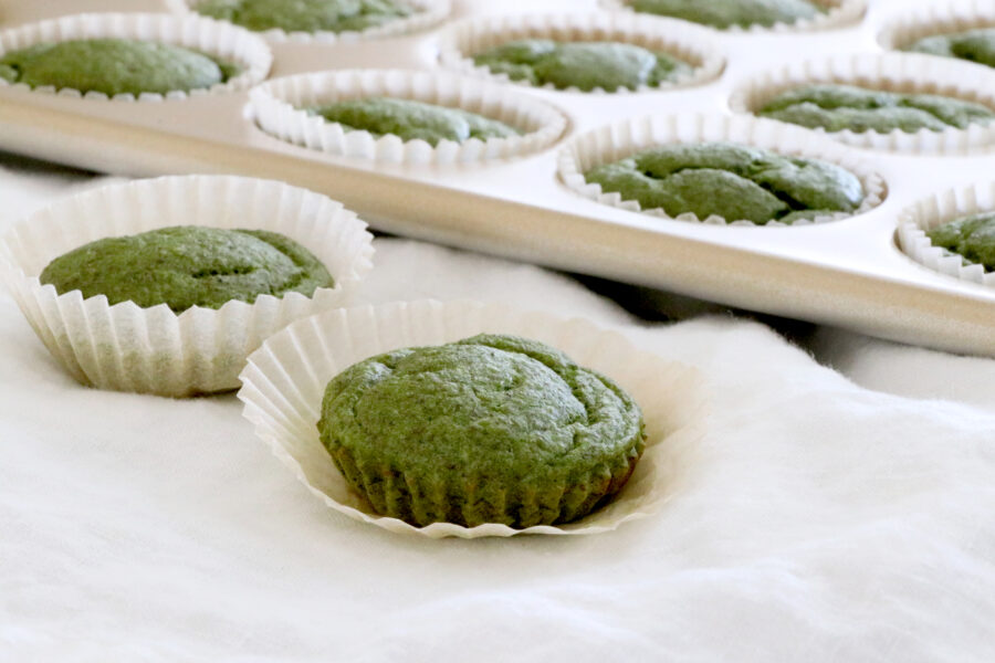 Green spinach muffins in muffin tin and out on counter.