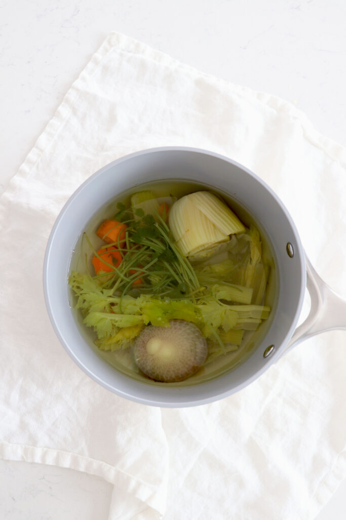 Saucepan with veggie stock from veggie scraps.