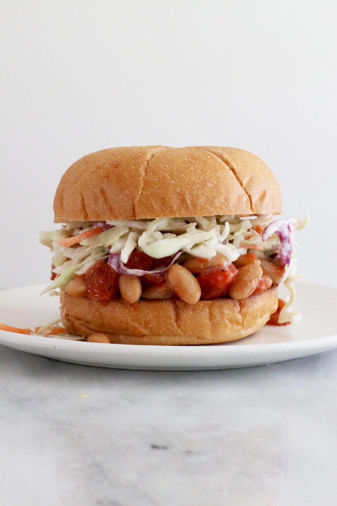 BBQ Bean Sloppy Joe Sandwich in the center of photo on top with white plate.